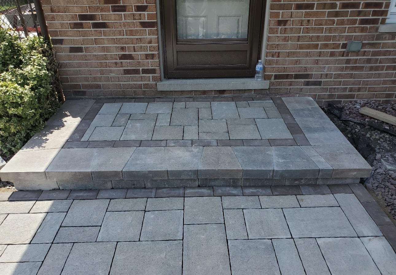 Finished grey paver stoop and walkway with contrasting charcoal border