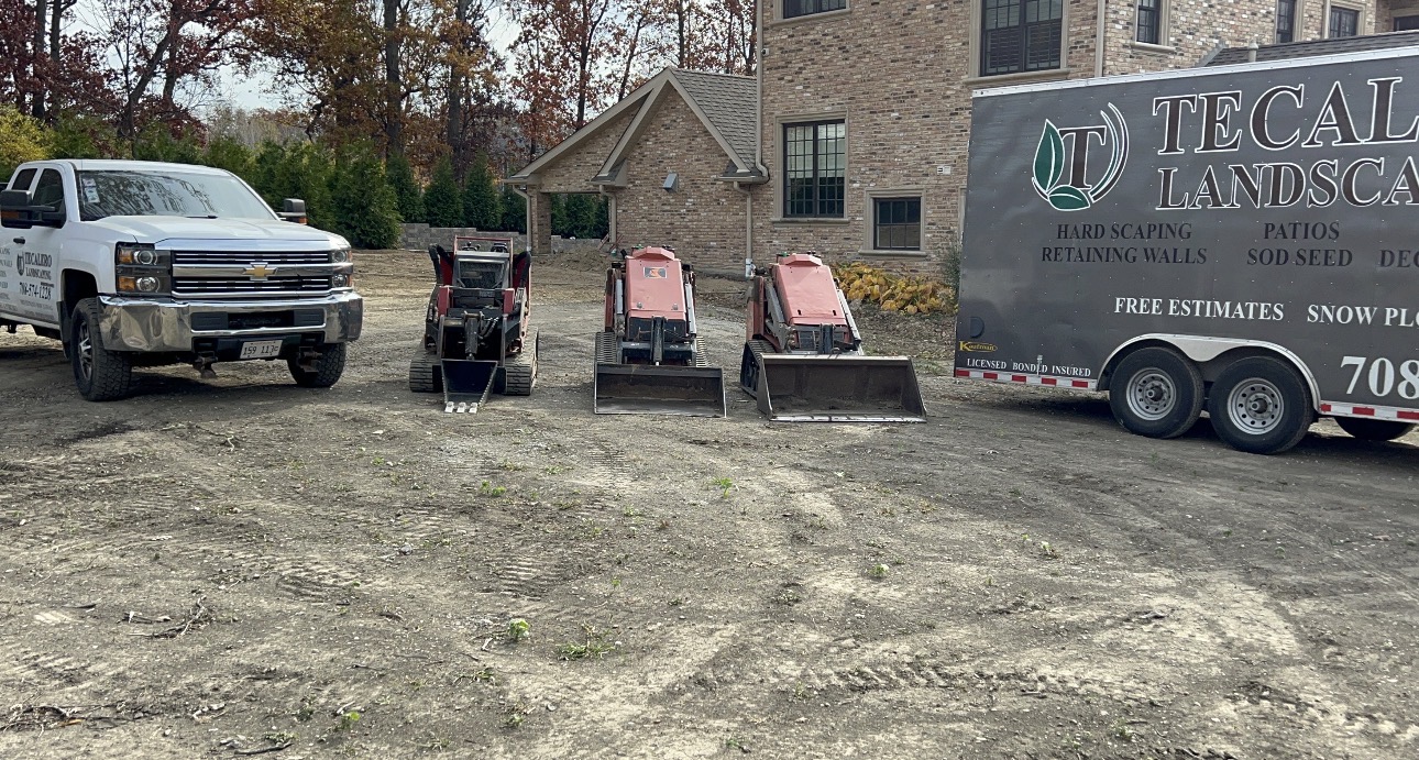 Tecalero Landscaping truck, trailer and track loaders staged on a residential job site